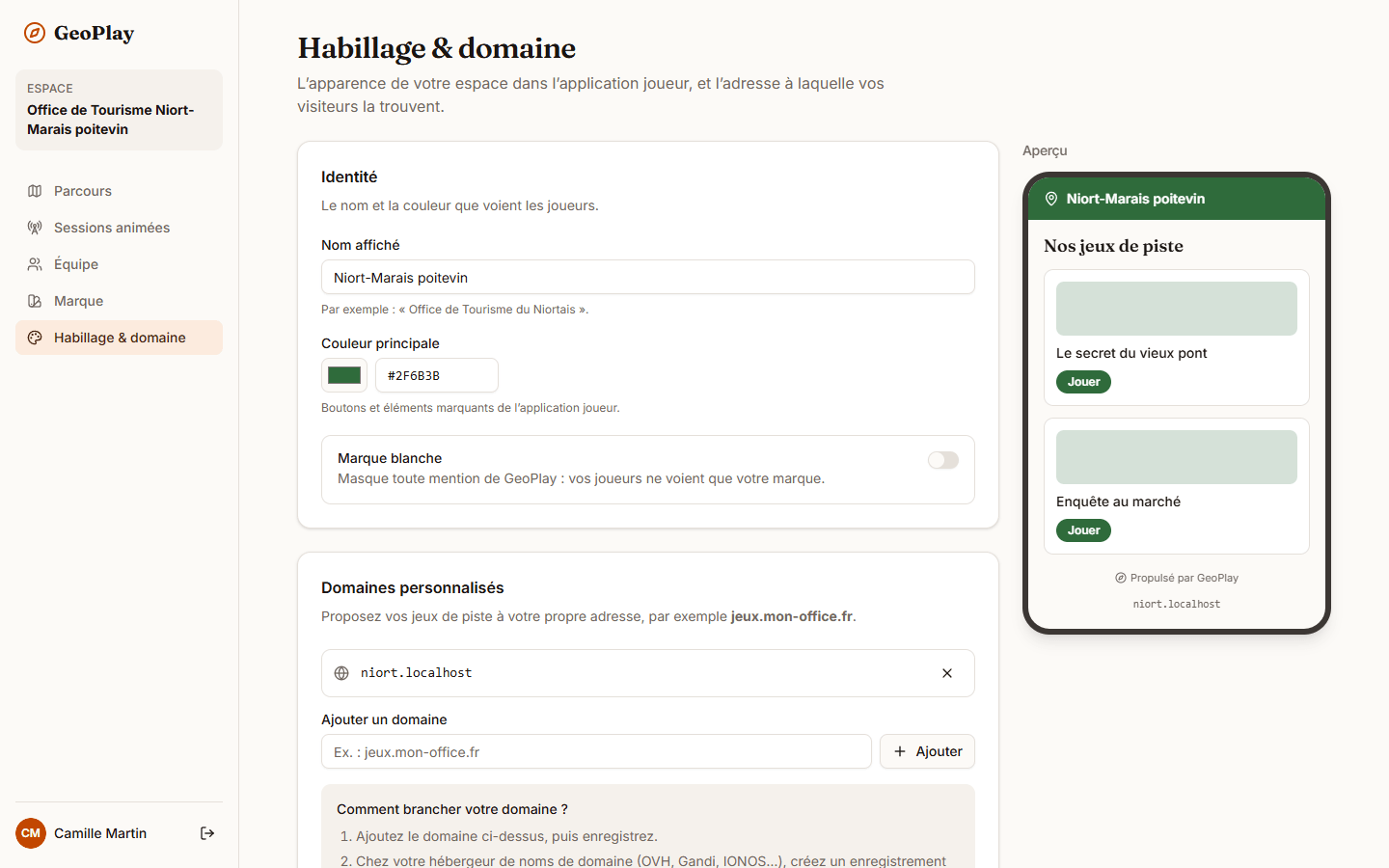 Page Habillage et domaine : carte Identité avec Nom affiché, Couleur principale et l’interrupteur Marque blanche, carte Domaines personnalisés avec l’encadré Comment brancher votre domaine, et à droite l’aperçu de la vitrine des joueurs.